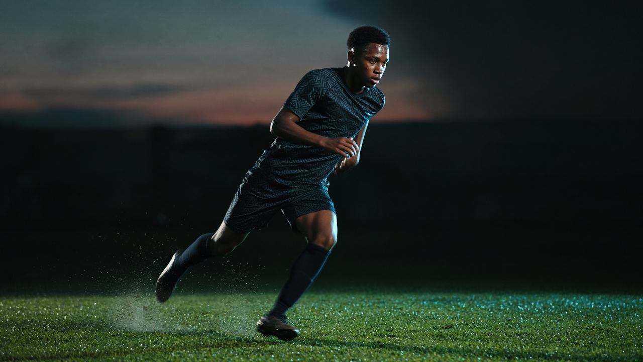 Soccer athlete accelerating on floodlit turf