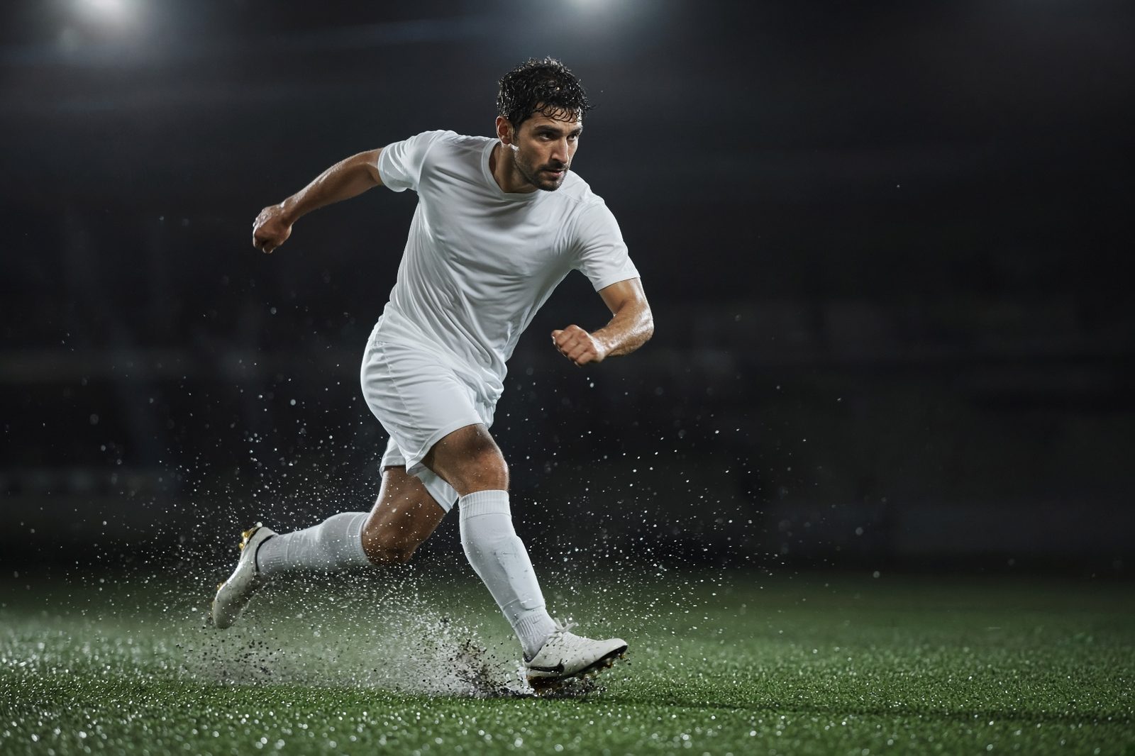 Soccer athlete cutting at game speed on floodlit turf, used to read force, hip and agility metrics